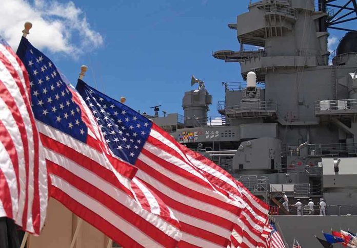 shutterstock_64270615.jpg American flags in front of a naval ship under a blue sky