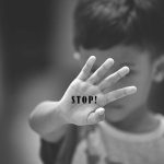 Horrifying Child Sex Ring Busted in Hidden Bunker Child holding up hand with "STOP!" written on palm.