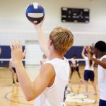 Volleyball Lawsuit IGNITES Women’s Sports Firestorm A young athlete preparing to serve a volleyball during practice