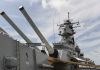 Close up of a battleships naval guns and superstructure against a cloudy sky