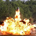 Explosive Tragedy Exposes Hidden Dangers A large explosion with flames and smoke in an outdoor setting