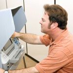 ELECTION SCANDAL Rocks Voting Machine Giant A man using an electronic voting machine in a privacy booth