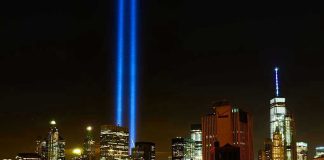 New York City skyline at night with memorial lights.