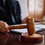 Judge holding gavel in courtroom.