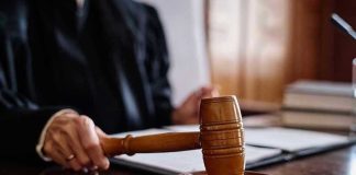 Judge holding gavel in courtroom.