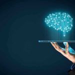 MIT’s TERRIFYING Mind-Reading Device Goes Live Hand holding tablet projecting digital brain hologram.