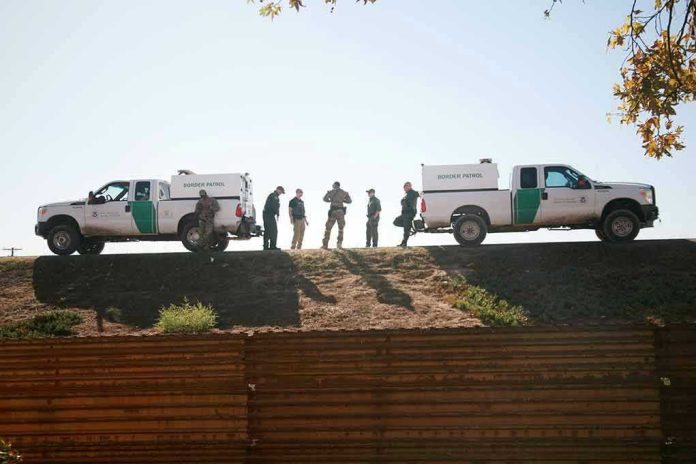Border Patrol vehicles and agents on a ridge.