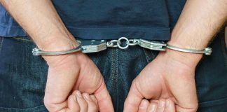 Person in handcuffs behind their back.