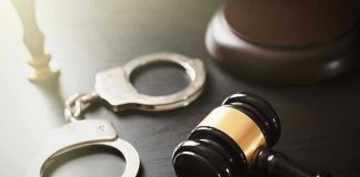 Handcuffs and judges gavel on the table.