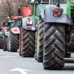 Tractors lined up on a city street.