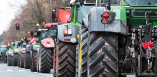 Tractors lined up on a city street.