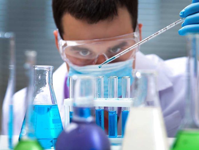 Scientist conducting an experiment with blue liquids in a laboratory