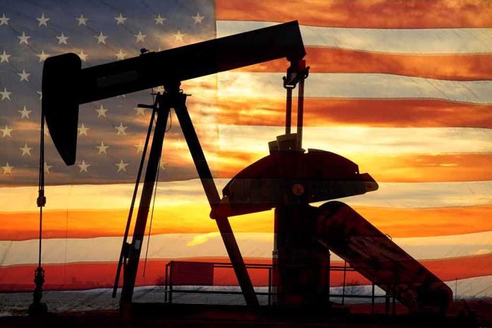 Silhouette of an oil pump jack against a sunset background with an American flag overlay
