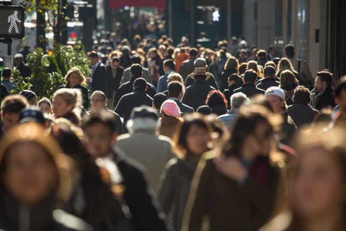 A crowded urban street filled with pedestrians walking in various directions