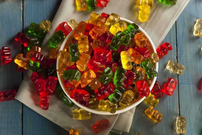 A bowl filled with colorful gummy bears surrounded by scattered candies