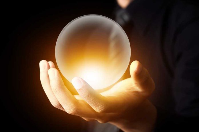 A hand holding a glowing crystal ball against a dark background