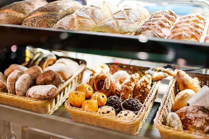 A display case filled with various types of baked goods including breads and pastries