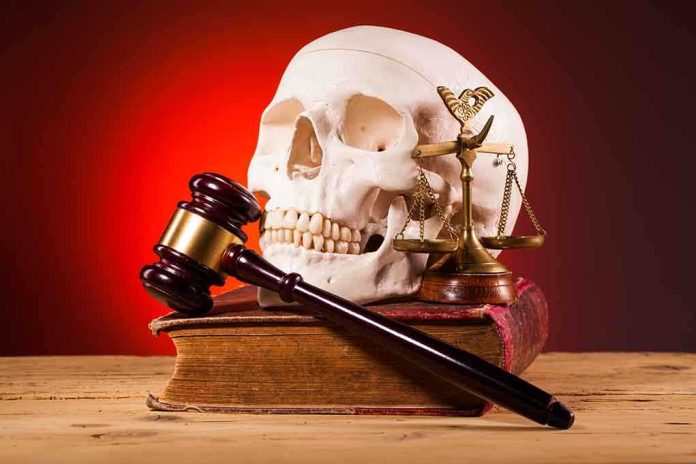 shutterstock_243278941.jpg A skull, gavel, and scales of justice on a book against a dark background