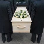Advocate’s Suicide Exposes BRUTAL System Failure Four people carrying a coffin with white flowers.