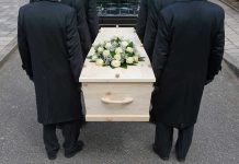 Advocate’s Suicide Exposes BRUTAL System Failure Four people carrying a coffin with white flowers.