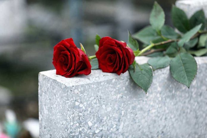 Two red roses on a grave.