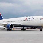Delta Cabin BRAWL Turns Violent FAST Delta Airlines airplane on airport runway, cloudy sky.