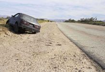 MISSING Minors Claim HAUNTS New Mexico Abandoned car on the side of a deserted road in a dry landscape