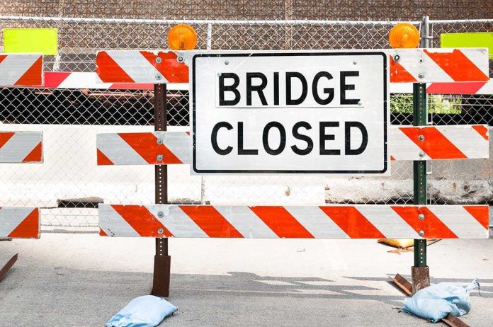 shutterstock_232337620.jpg A Bridge Closed sign surrounded by safety barriers and fencing