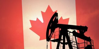 Silhouette of an oil pump jack against a Canadian flag background