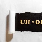 Torn paper revealing UH-OH text underneath.