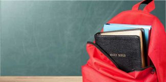 Red backpack with a Bible and books inside.