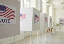 Voting booths with American flag and VOTE signs.