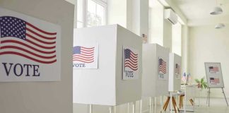 Voting booths with American flag and VOTE signs.
