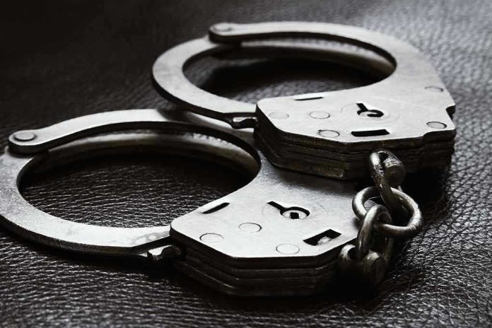 2385593779 Close-up of metal handcuffs on a dark surface.