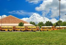 Knife Horror Inside NYC Middle School A row of yellow school buses parked in front of a school building under a cloudy sky