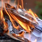 Burning papers with flames and smoke rising