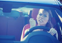 Angry woman gripping the steering wheel in a car