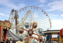 Ride FREEZES Mid-Air At Houston Rodeo Colorful amusement park scene featuring a ferris wheel and carousel