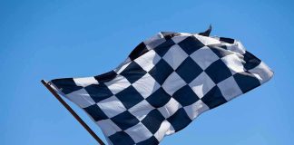 A checkered flag waving against a clear blue sky