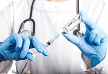 Pfizer HALTS Massive Vaccine Trial – 80% FAILED! Doctor filling syringe with vaccine from vial.