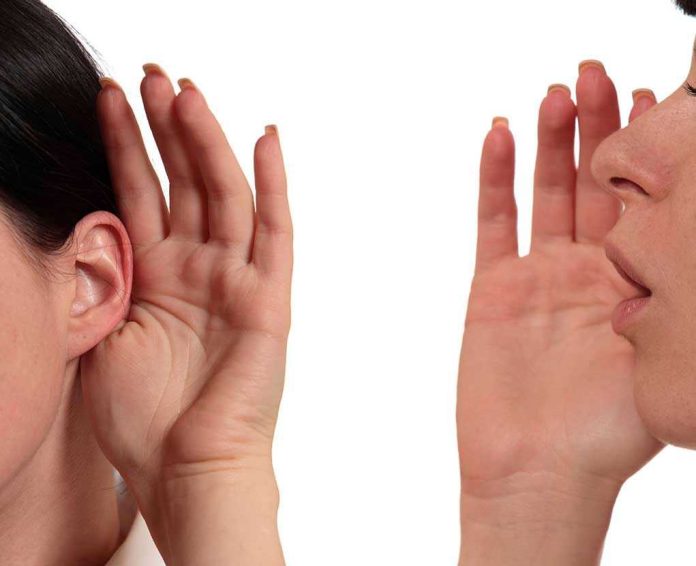 Person whispering into another persons ear gesture