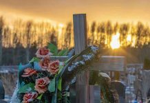 TREE CRUSHES Mother and Baby at Easter Hunt Cross with flowers at cemetery during sunset.
