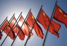 China CRUSHES America in SUV Race Red flags with yellow stars on flagpoles.