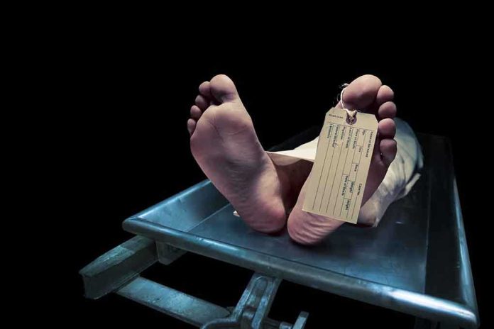 Feet of a deceased person on a coroners table with an identification tag