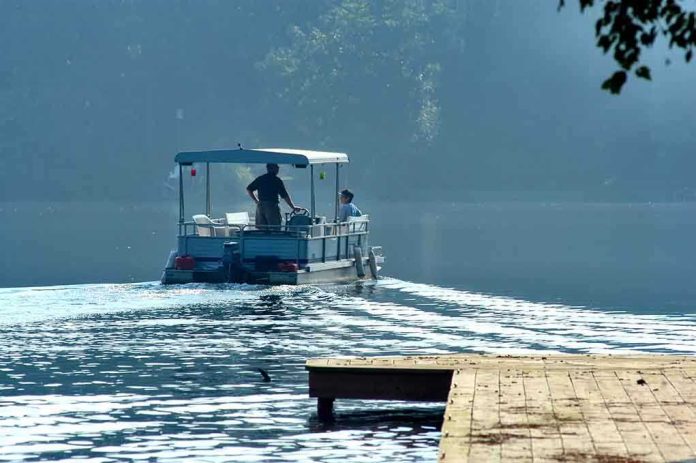 Two people on a boat navigating a misty lake