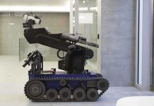 A robotic arm mounted on a tracked base in a modern workspace