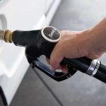 A hand holding a diesel fuel nozzle while refueling a vehicle