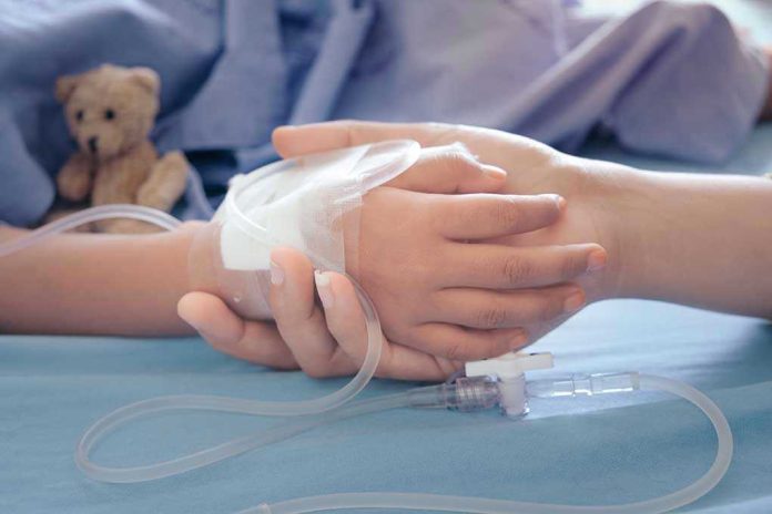 Childs hand with IV, held by adult.