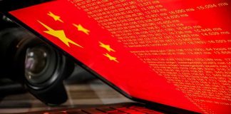 Shocking Foreign Agent Charge: U.S. Commentator Tied to China Laptop screen displaying Chinese flag and code.