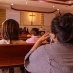 Vatican Unveils LGBTQ+ Report—Conservatives Outraged! People sitting in church pews during service.